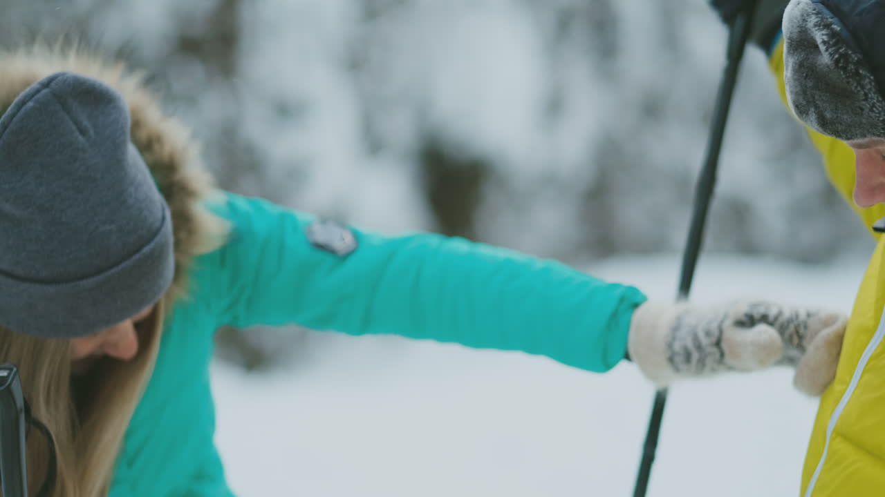 un hombre y una mujer esquiando en el bosque de invierno