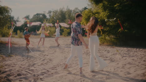 young couple dancing bachata while friends enjoying weekend party