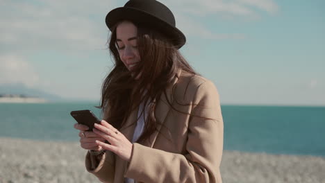 woman on the beach using mobile phone