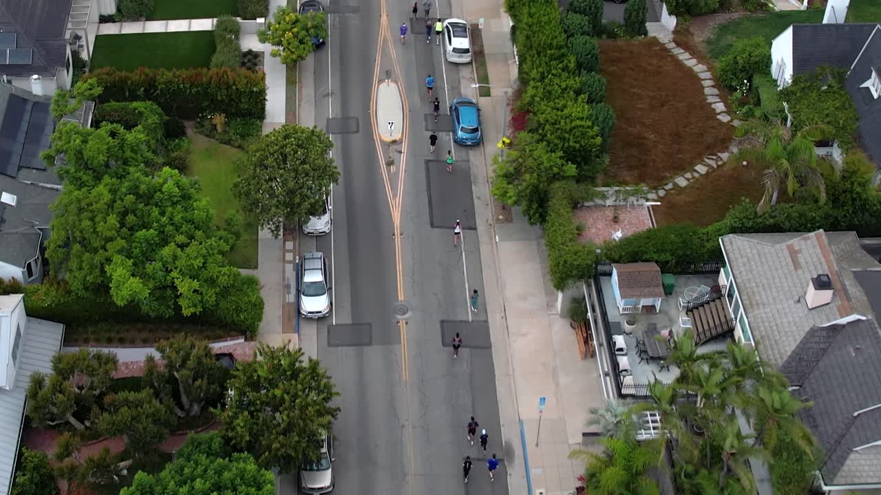 커뮤니티 피트니스 행사를 위해 거리를 달리는 조깅하는 사람들 - 공중 보기
