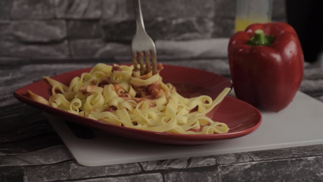 Eating tomato sauce over freshly cooked tagliatelle pasta wide shot
