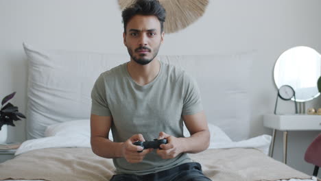 man playing video game in bedroom