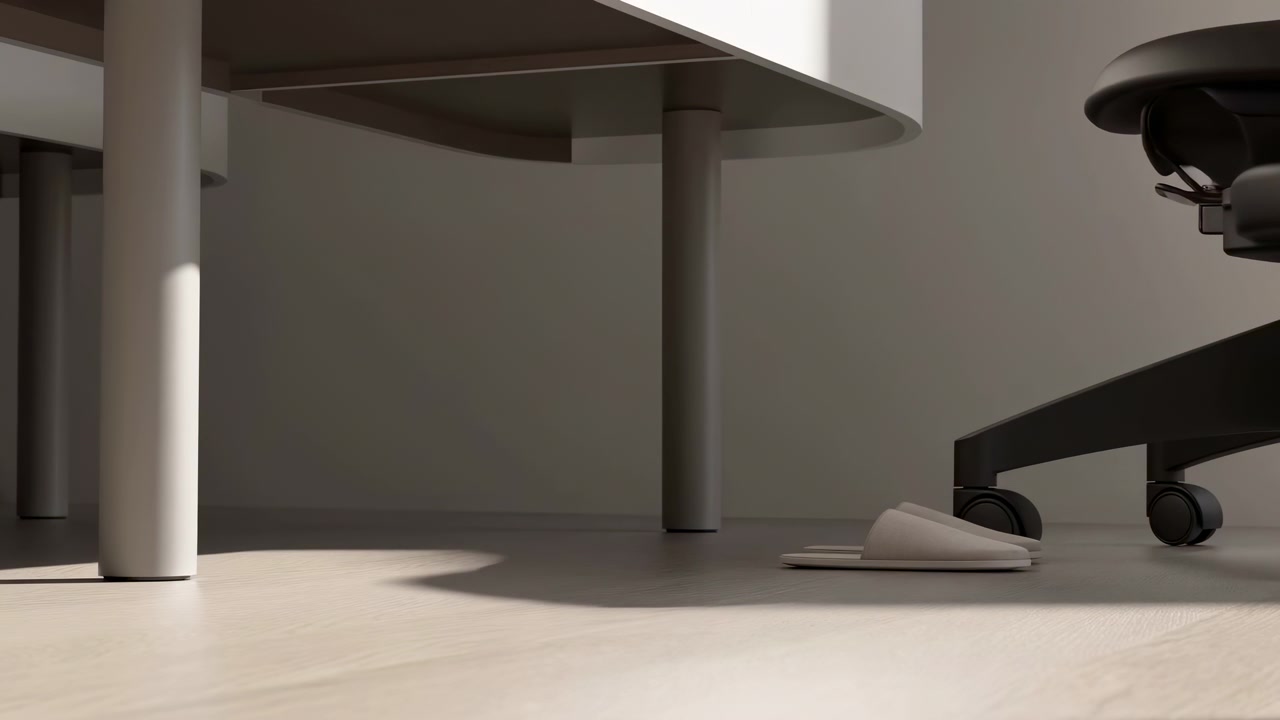 Low floor-level view shows white open slippers positioned under a rounded desk near chair casters, while soft directional sunlight creates defined shadows across light wood flooring.