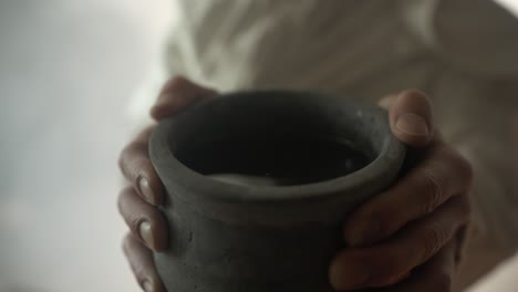 closeup of jesus christ holding a clay jar of wine, as a representation of the last supper, communion, christian sacraments, and the shed blood of jesus on the cross. perfect for easter sunday visual.