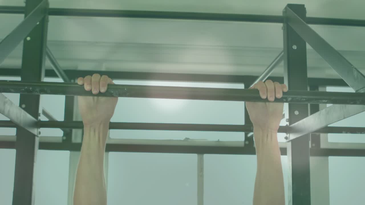 Man gripping pull-up bar and starting pulling for fitness, camera capturing top holds and lowering