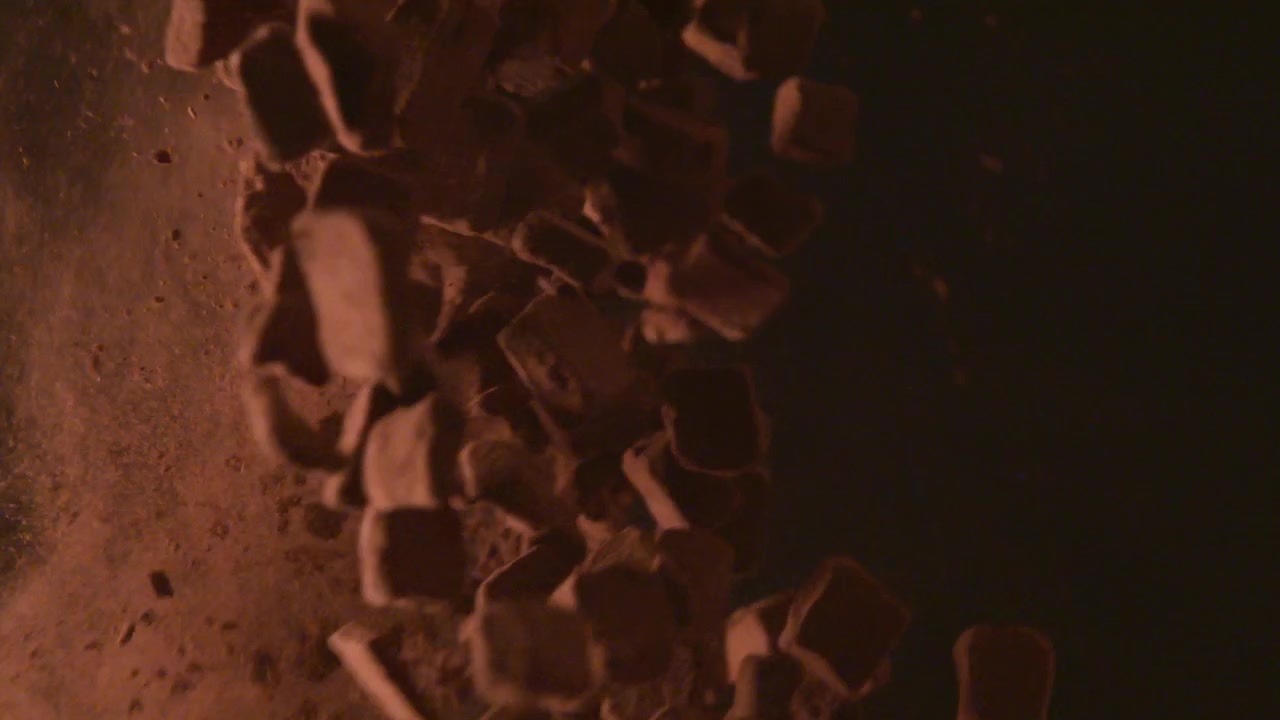Mixing chocolate cubes with Fine cocoa powder, on a black background, Mixing with a silver bowl