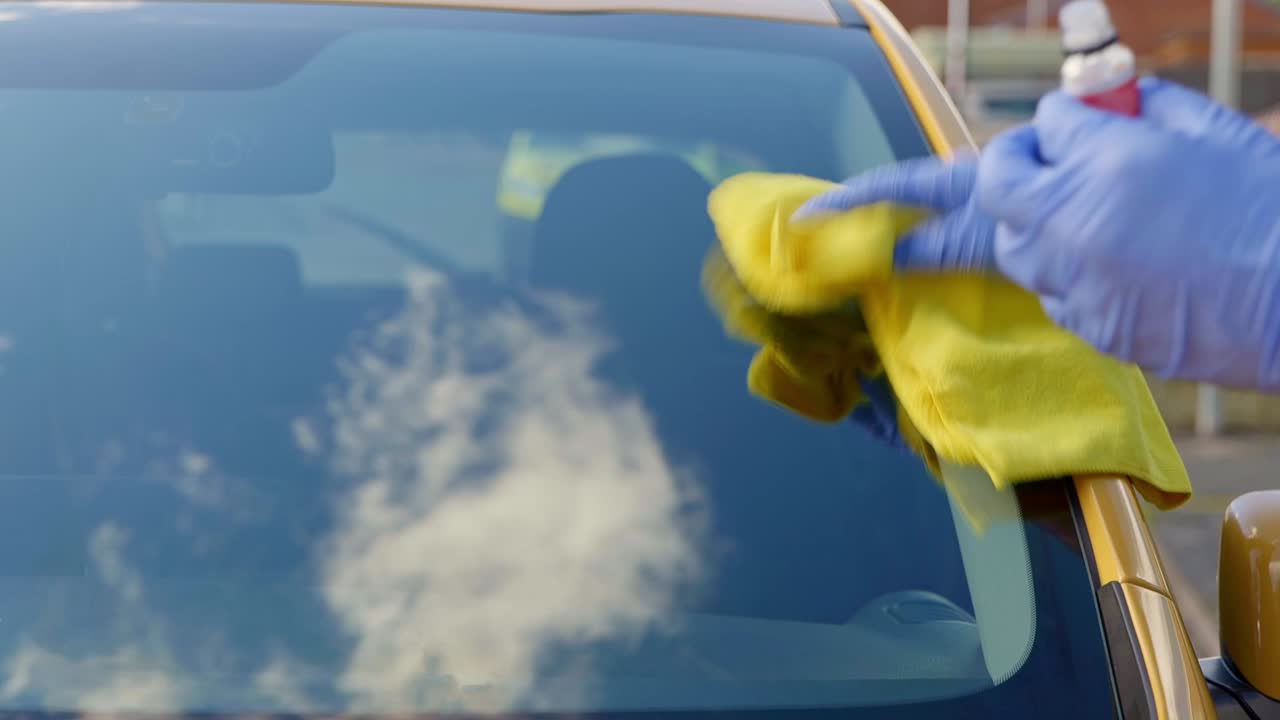 Removing ceramic coating from front window screen on a yellow car using a yellow microfibre cloth towel