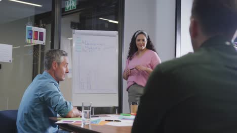 Happy-diverse-business-people-discussing-work-during-meeting-at-office