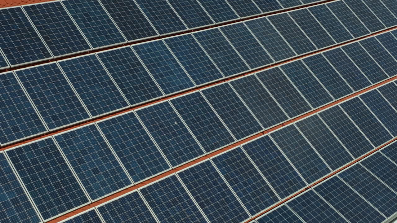 los paneles solares alinean el techo inclinado de un edificio, aprovechando la energía renovable, con el cielo azul reflejado en su superficie