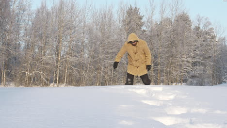 Man-in-winter-clothes-walks-in-deep-forest-snow-in-extreme-cold-weather