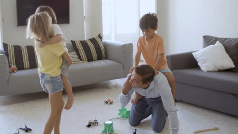 Caucasian-dad-and-kids-playing-in-living-room-together