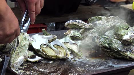 man open oyster on the grill