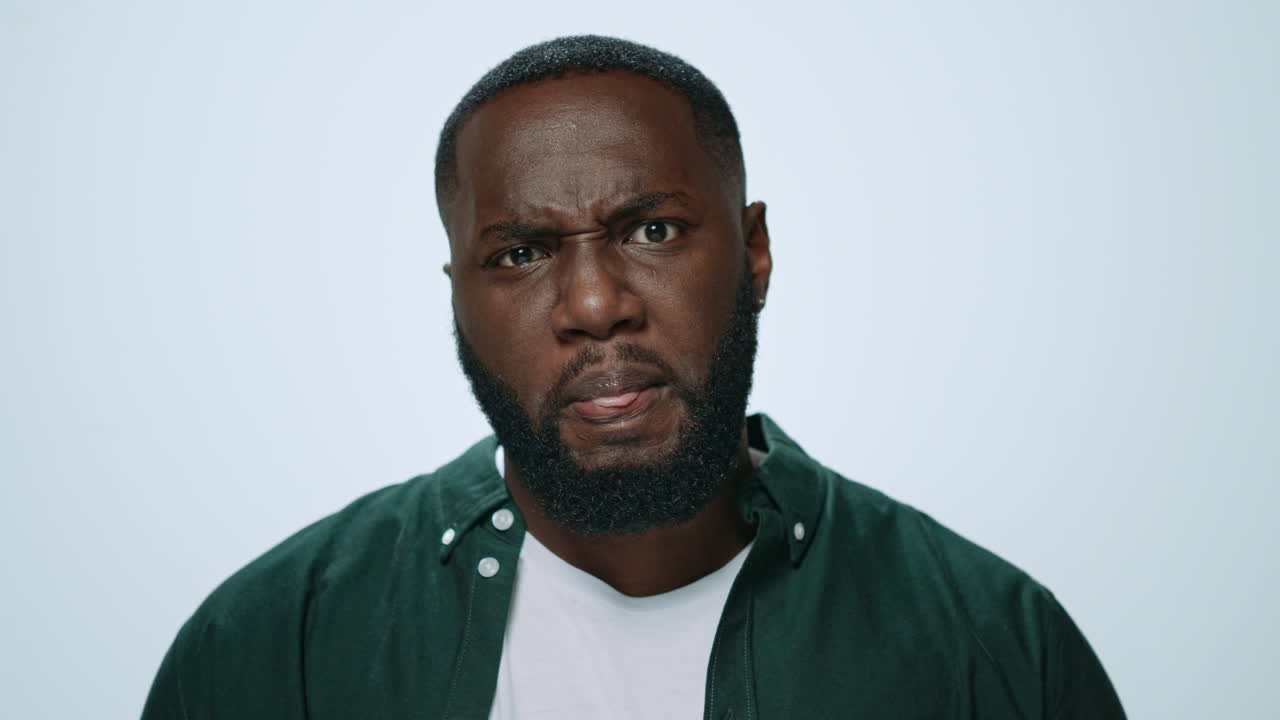 Portrait of thoughtful african american man posing on grey background.
