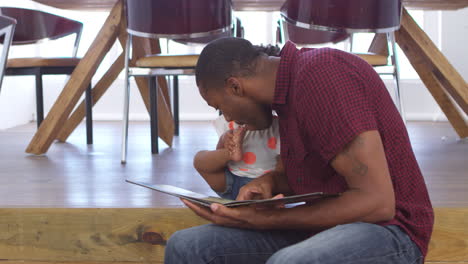 Father-Kisses-Young-Daughters-Toes-As-They-Read-Story-Together