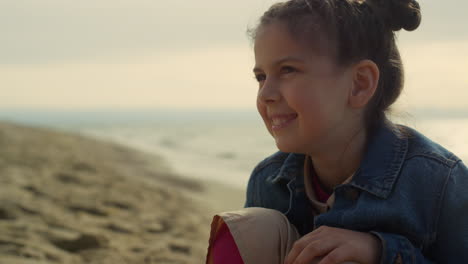 joyful kid feeling happy on sea beach. cheerful child face smiling on shore sand