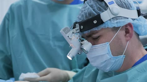 operation to remove tonsils. in modern clinic under deep anesthesia, using latest devices patient removes glands, cold plasma method, cuts swelling in throat, doctor works with new probe, close-up, new medical technologies