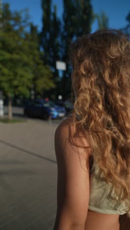 woman with curly hair walking on the street