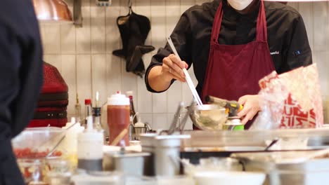 chef cooking and plating food in a busy kitchen