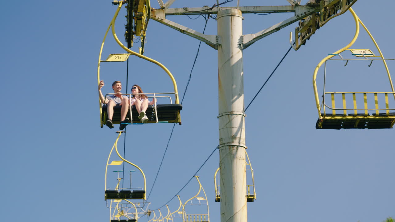 un par de amigos viajan en un remonte de vacaciones en las montañas en el verano 4k video de 10 bits