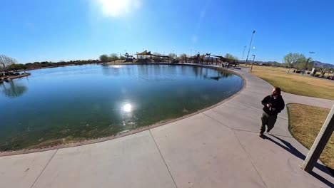red haired male in mansel crater park in queen creek arizona towards ducks.