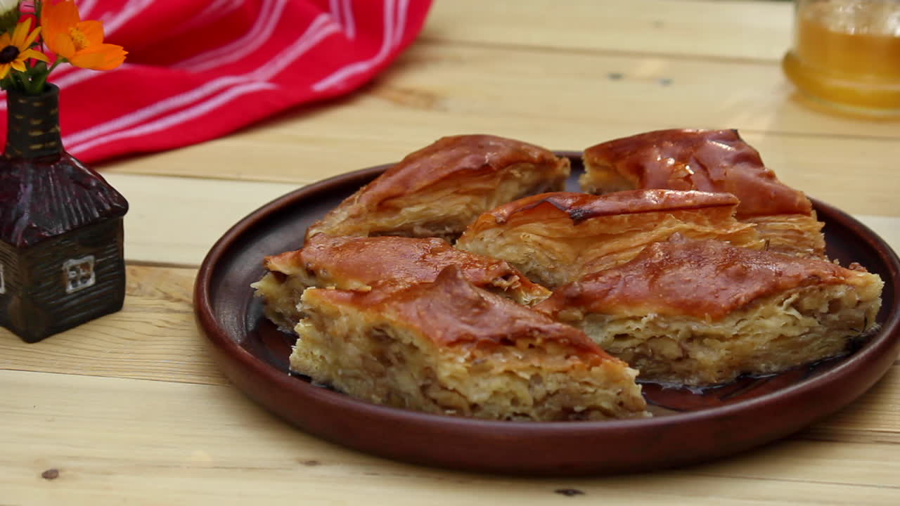 Baklava fresco sobre a mesa ao lado de uma tigela de frutas