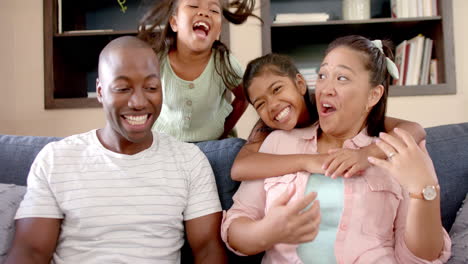 laughing together, happy family of four bonding on couch at home
