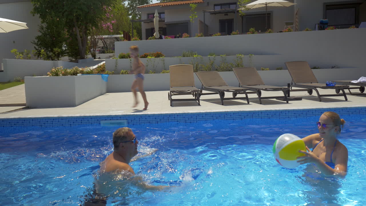 hombre y mujer jugando a la pelota en la piscina