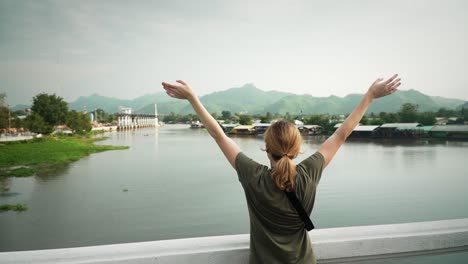 lady celebrating throwing arms in air and looking at beautiful nature