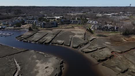 aerial pullback showing salt marsh and a marina in background