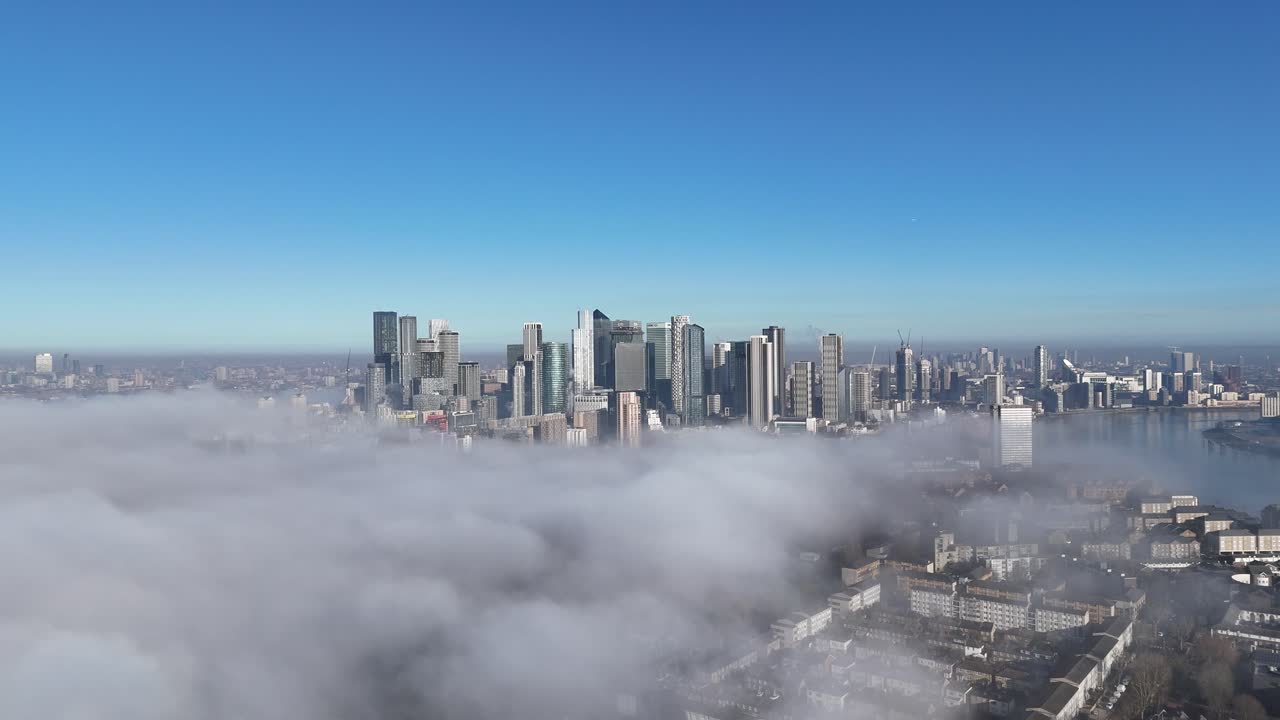 Breathtaking aerial footage of London's Canary Wharf and Central Business District, showcasing iconic skyscrapers through a rare cloud inversion for a stunning visual experience.