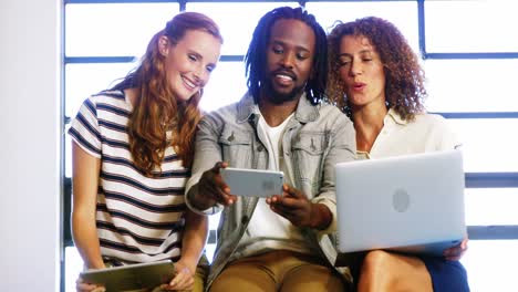 business executives discussing over digital tablet and laptop
