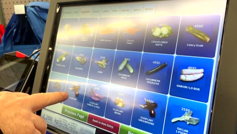 person using self checkout screen automated cash register to select vegetable grocery to purchase in supermarket