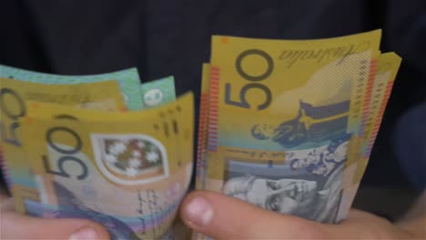 cerca de manos masculinas contando dinero australiano