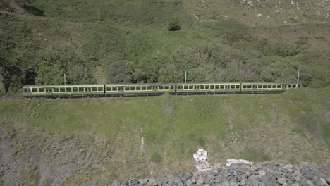 train exiting tunnel in bray head mountain in county wicklow, ireland on a sunny day