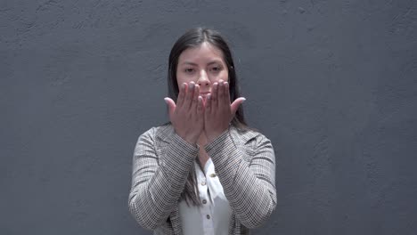 smiling latina girl gestures a call with her fingers, conveying joy and friendliness in a friendly and warm gesture