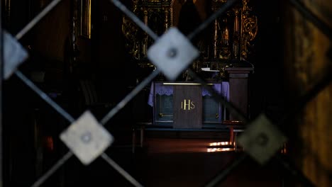 View-of-altar-and-cross-of-Christ-through-cast-iron-gate-of-famous-wooden-Polish-church-on-St