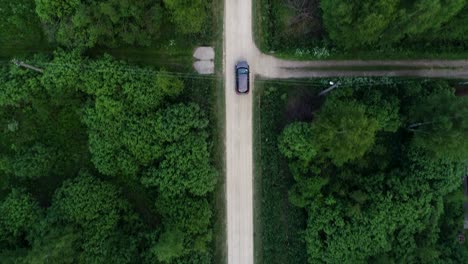 the village road. the car rides along the road between trees and houses.