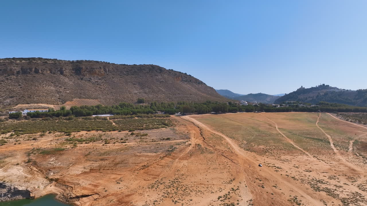 el vuelo sobre los suelos marrones amarillos de la playa de valdearenas del embalse de iznajar expone el profundo efecto del calentamiento global y la reducción masiva de los niveles de agua del lago.