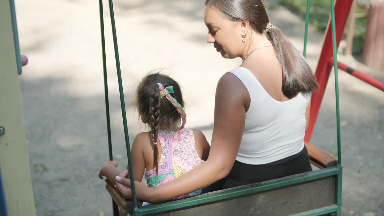 madre y hija embarazadas jugando en el columpio al aire libre