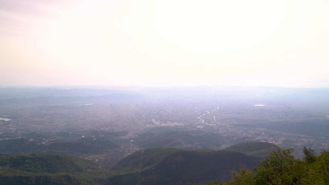 muy por encima de la vista con un amplio paisaje abierto y una ciudad contaminada en el fondo