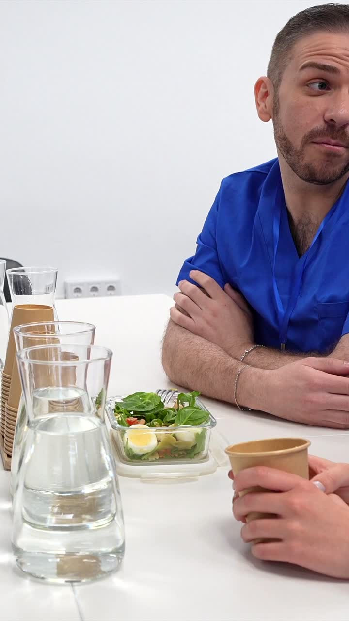 Diverse fagpersoner diskuterer og spiser frokost på et kontor