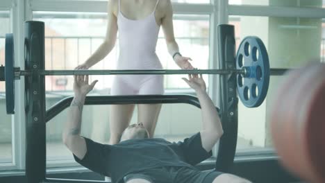man and woman exercising in gym, weightlifting session