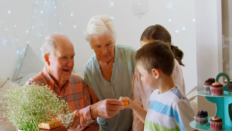 Caucasian-grandfather-giving-chocolate-to-grandson-in-a-comfortable-home-4k