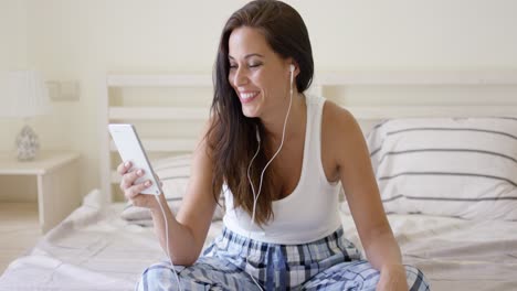 happy woman listening with ear buds and tablet