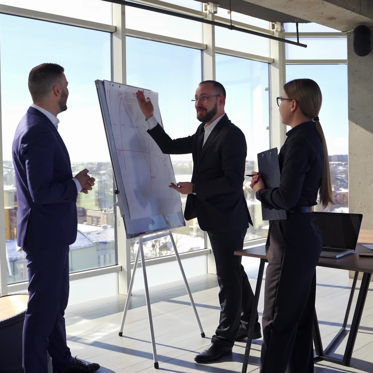 Positive business partners speaking. Teamwork of entrepreneurs in suits having a joyful conversation in office centre in the city