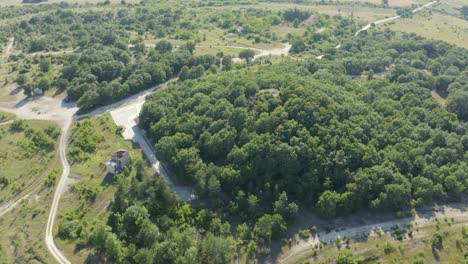 mezek tomb - thracian tumulus covered by green trees at mezek, bulgaria