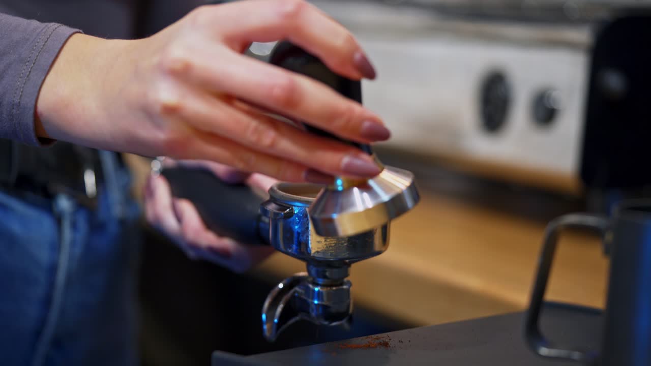 Woman prepares coffee.Barista filling the grinding coffee beans into the special part of coffee machine. Making coffee at home. Close-up.