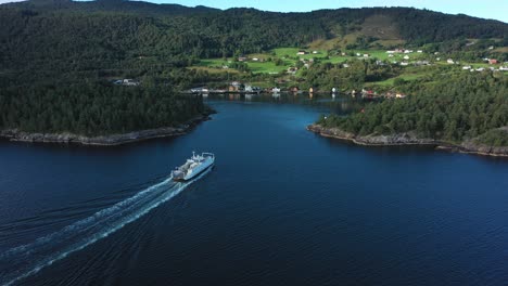 norwegian car and passenger ferry ytteroiningen approaching port of utbjoa - beautiful aerial view from the side and behind during sunny morning