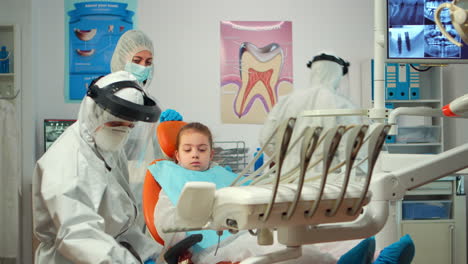 pediatric dentist in protective suit lighting the lamp until examination