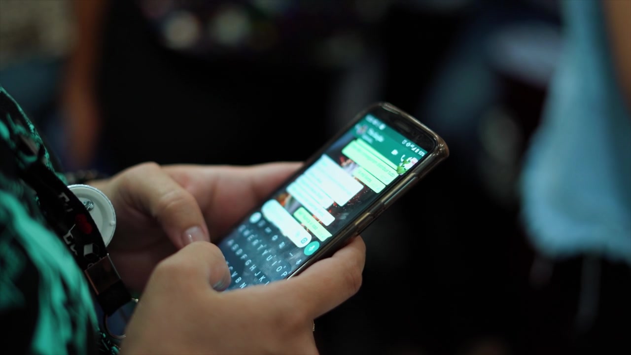 Ręce piszące SMS-a na telefonie komórkowym, tworzące wiadomość